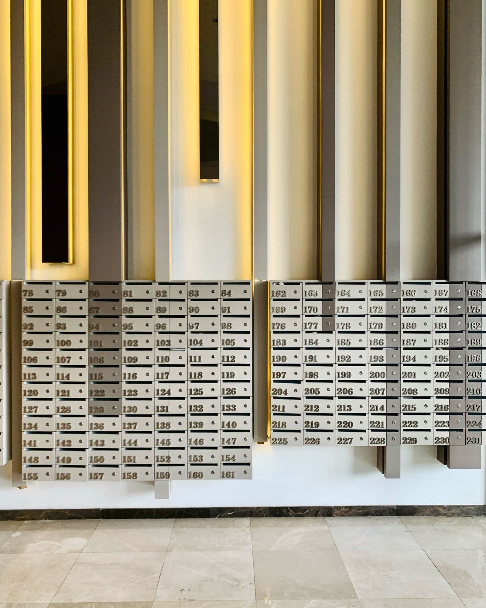 Modern wall-mounted commercial mailbox bank in an apartment community lobby